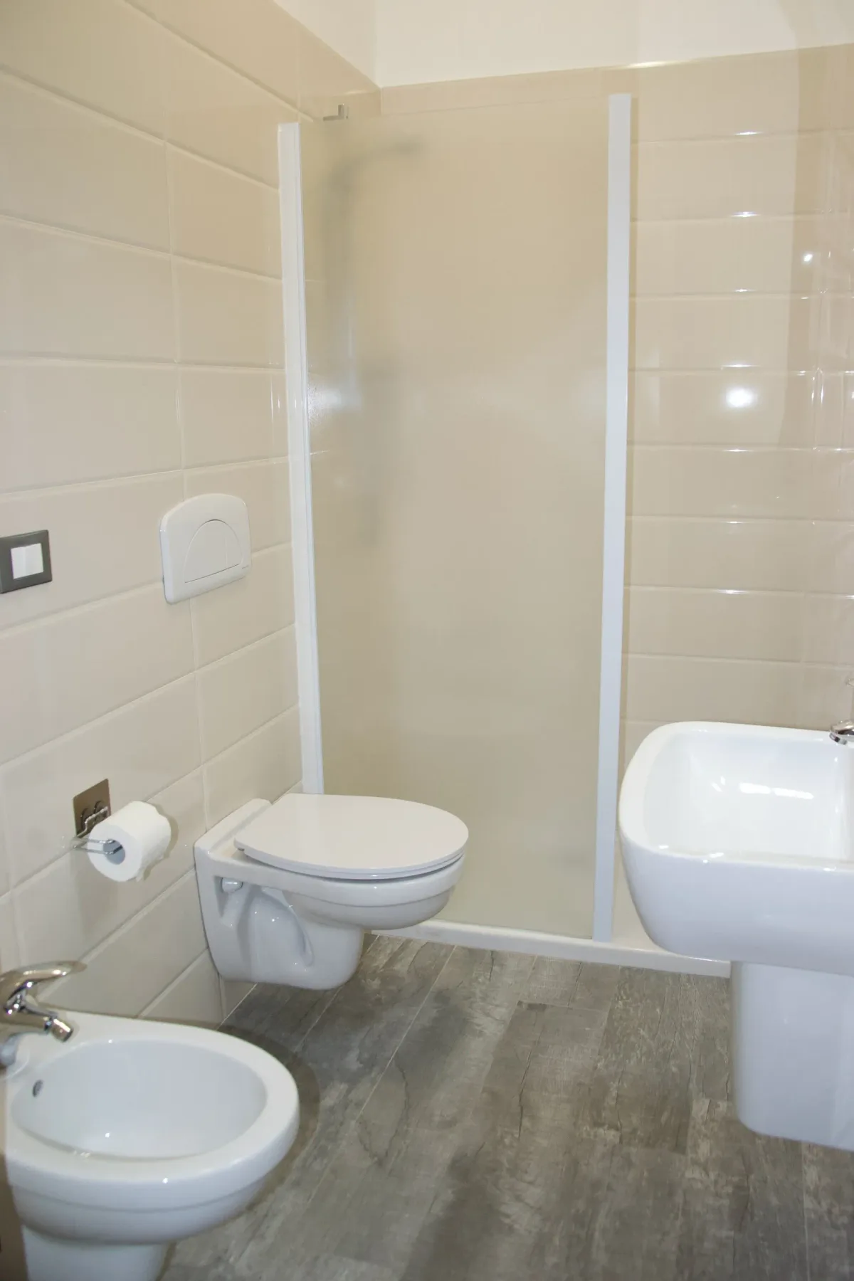 Baño con inodoro, lavabo y ducha.