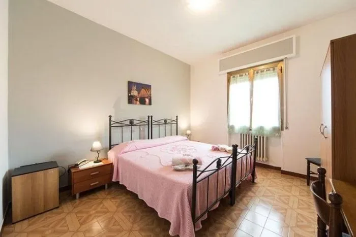 Habitación de huéspedes con una cama tamaño king y dos mesas de noche.