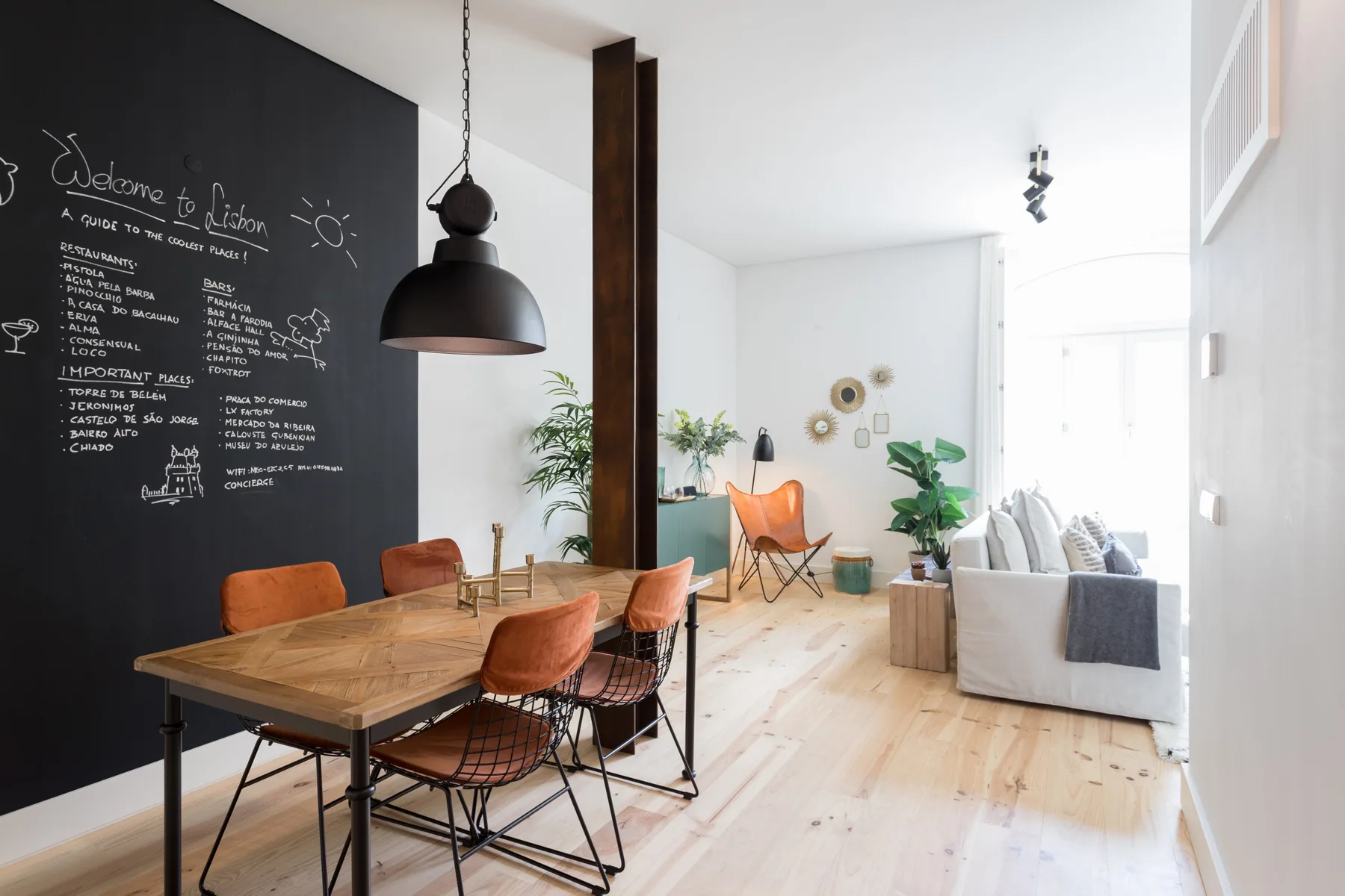 A bright open-plan living and dining area with a wooden table and seating.