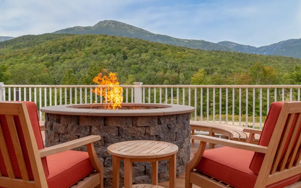 Zona de descanso al aire libre con fogata y vistas a las montañas en The Glen House