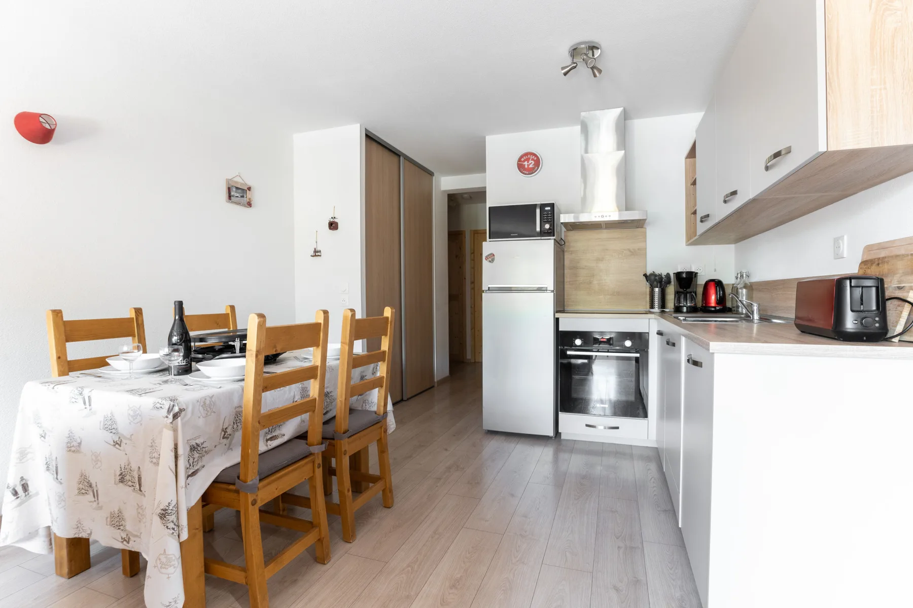 A kitchen and dining area with a table beside the countertop.