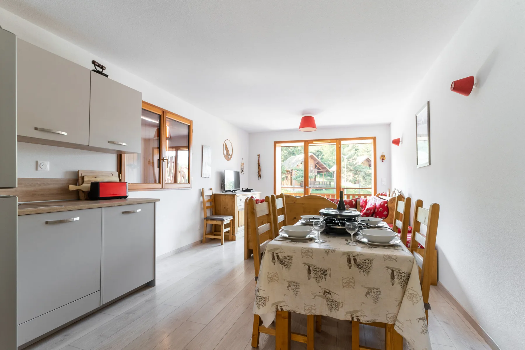 A dining area with a table set beside a kitchen.