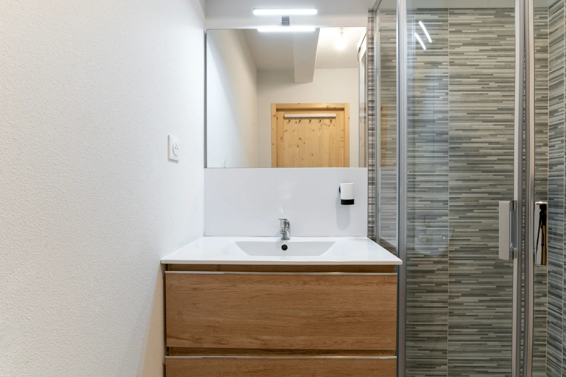 Bathroom with a sink and a glass-enclosed shower.