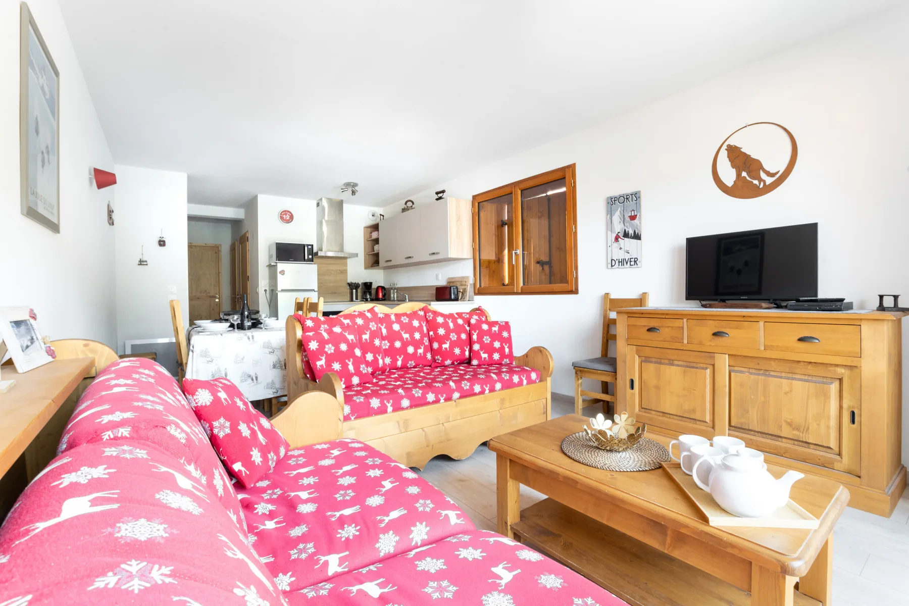 A living room with pink patterned seating and a wooden coffee table.
