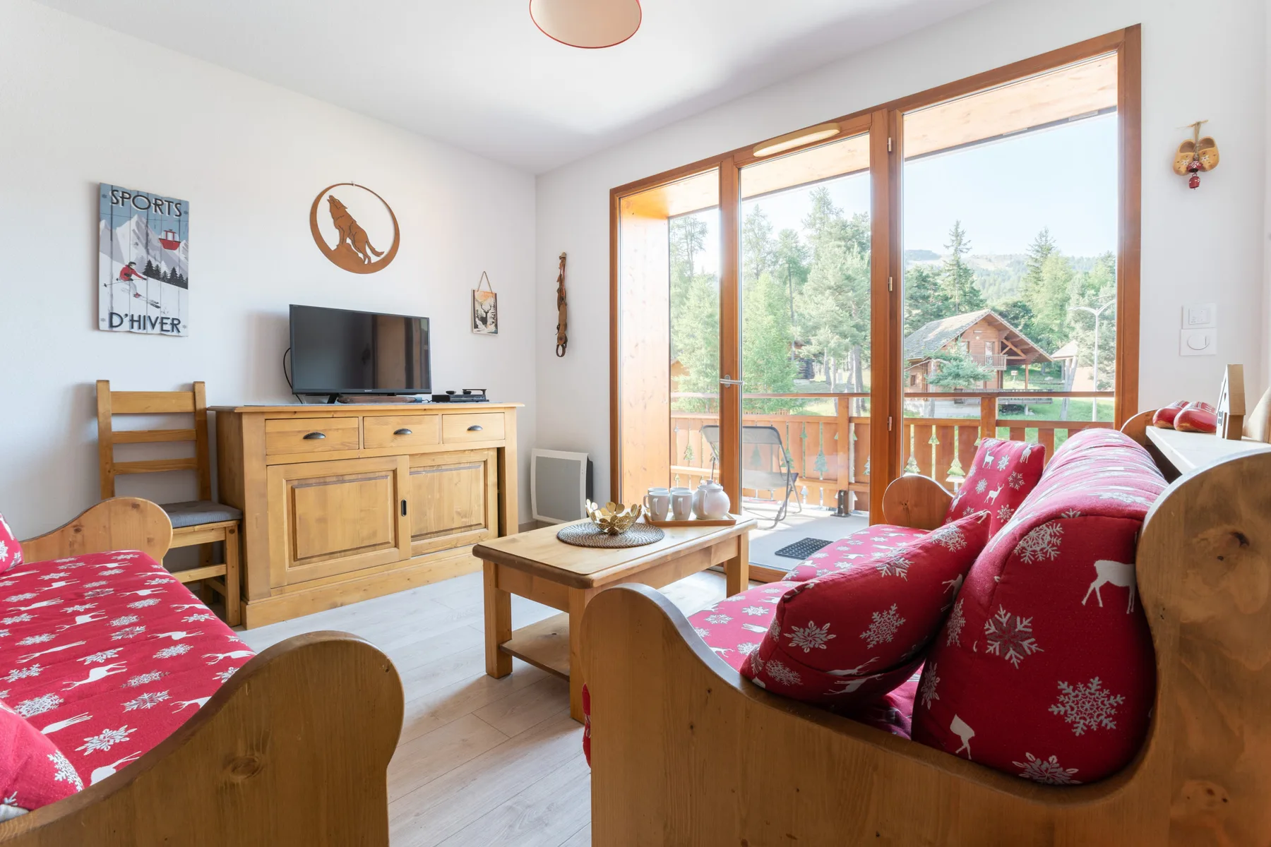 A living room with red patterned seating and a wooden coffee table.