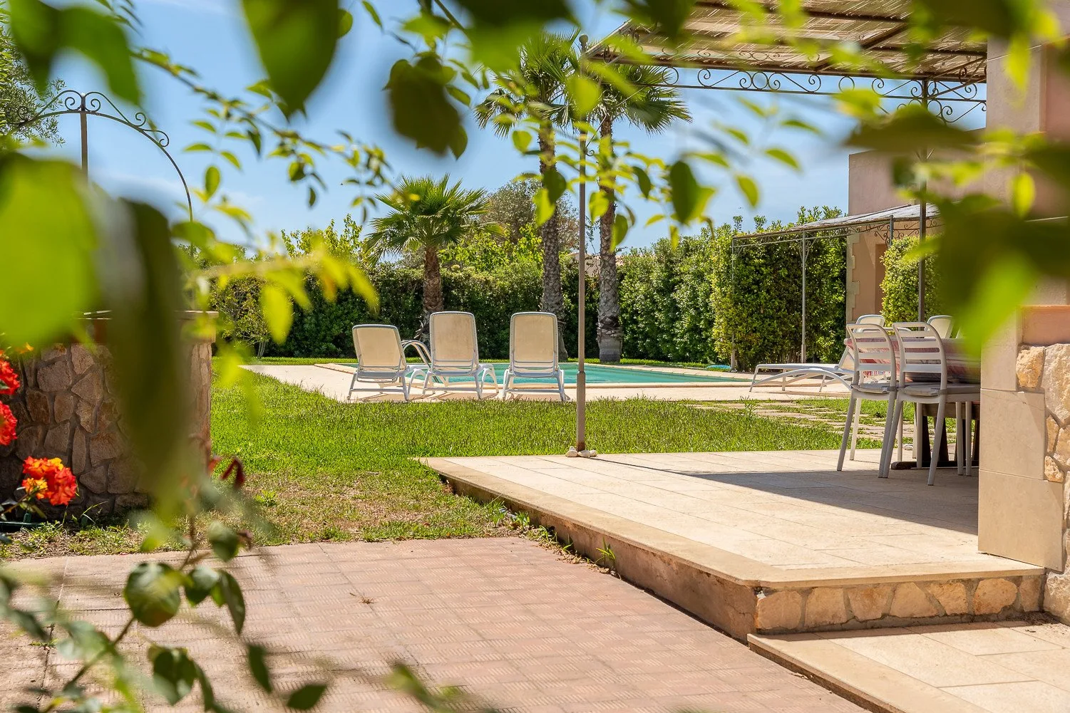 Una zona de piscina al aire libre con asientos junto a un patio elevado.