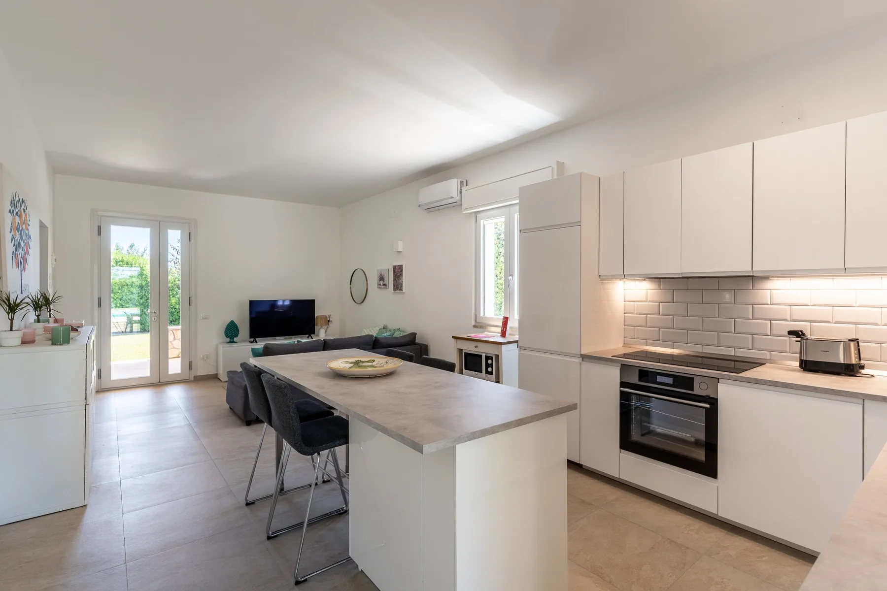 Una luminosa cocina abierta al salón, con una isla y una zona de estar.