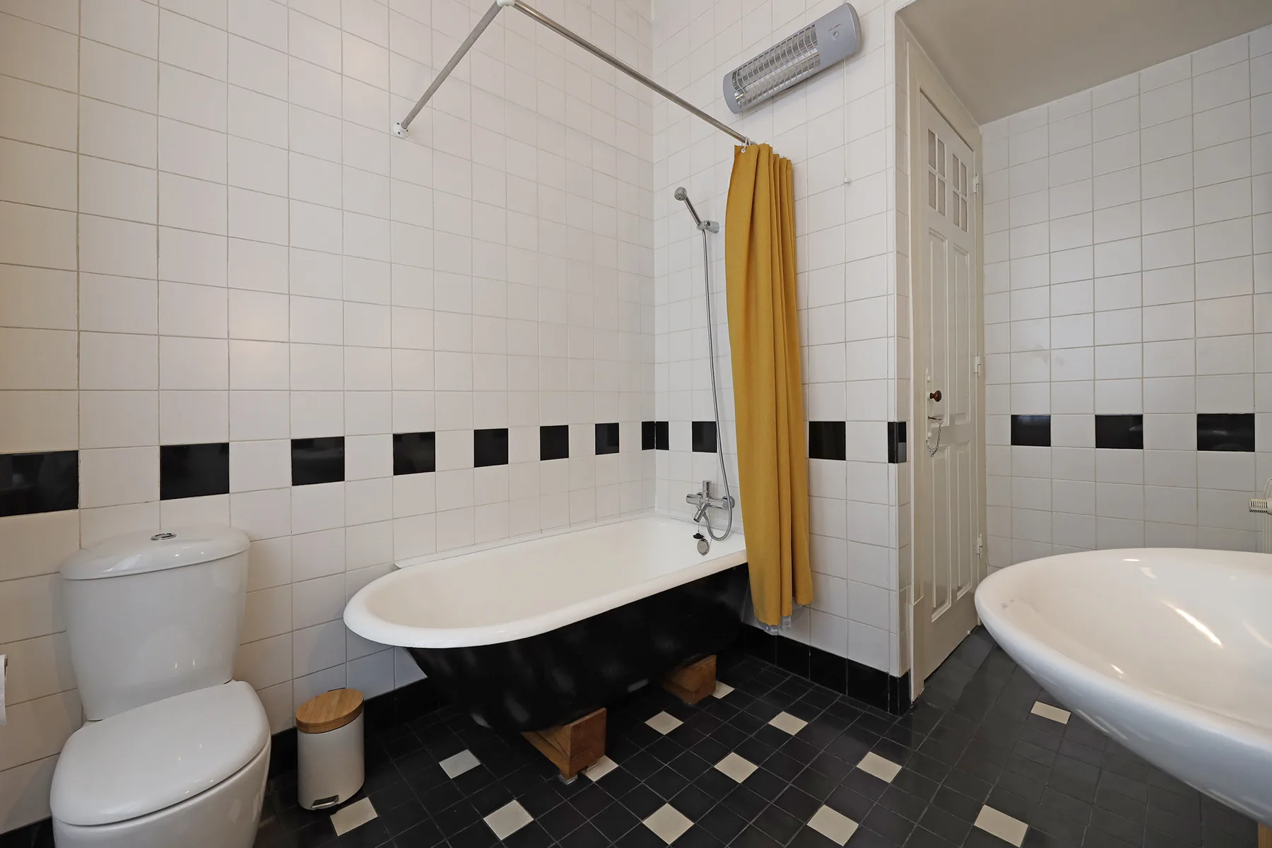 Un baño alicatado con bañera, inodoro y ducha.