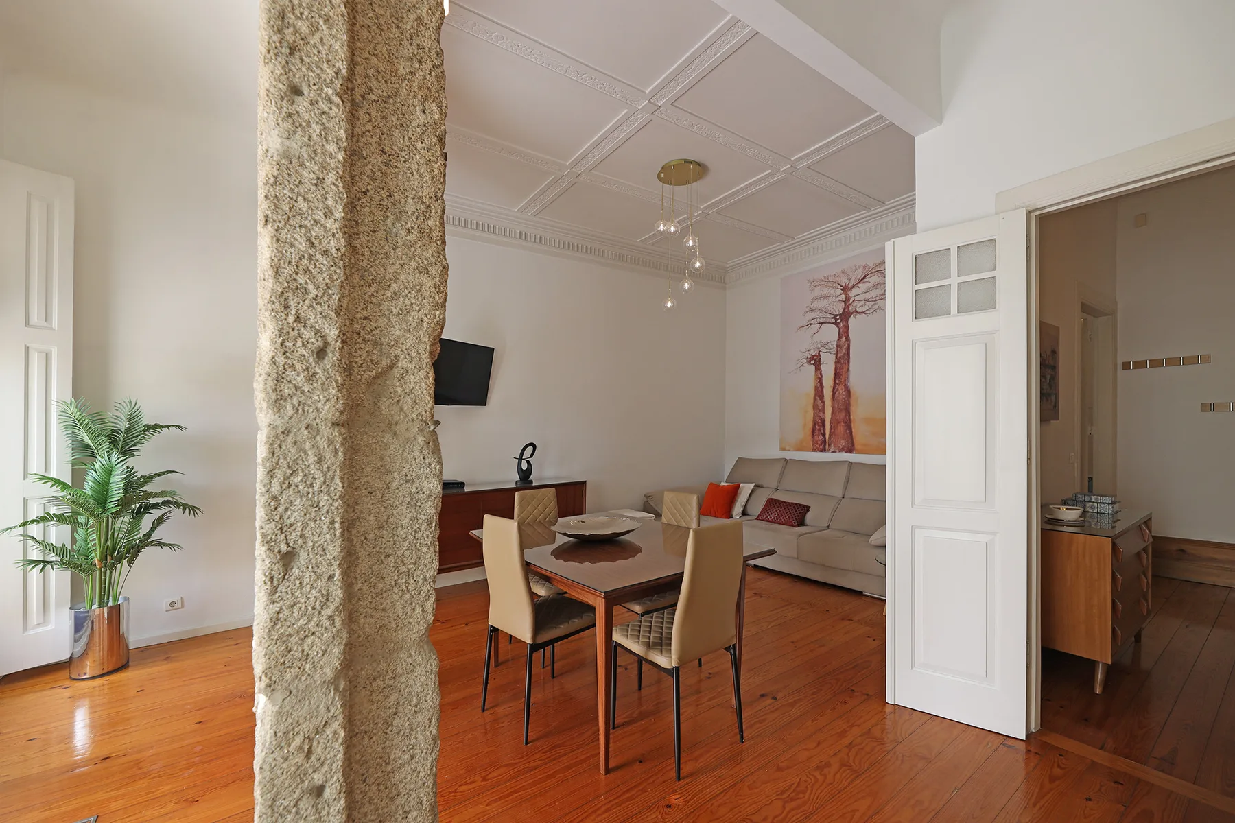 A living and dining area with a table, seating, and a television.