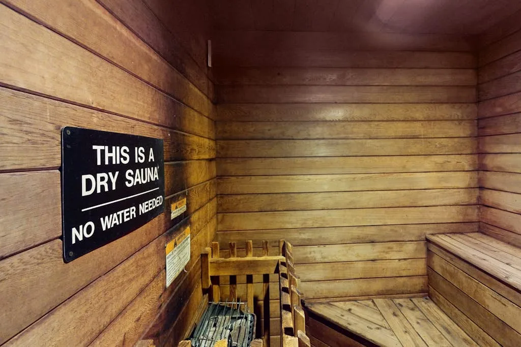 Una sauna seca revestida de madera, con bancos y un letrero en la pared.