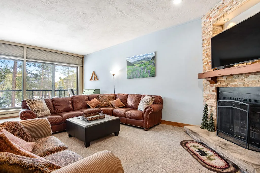 A living room with brown seating, a coffee table, and a fireplace.