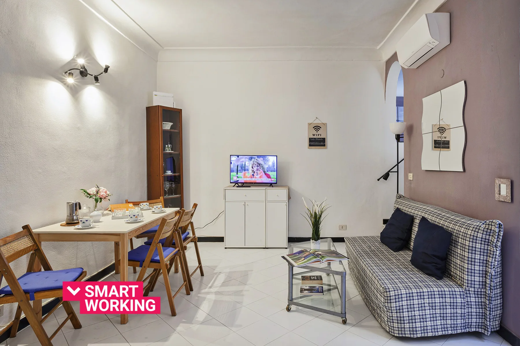 Una sala de estar y comedor con televisor, mesa y asientos.