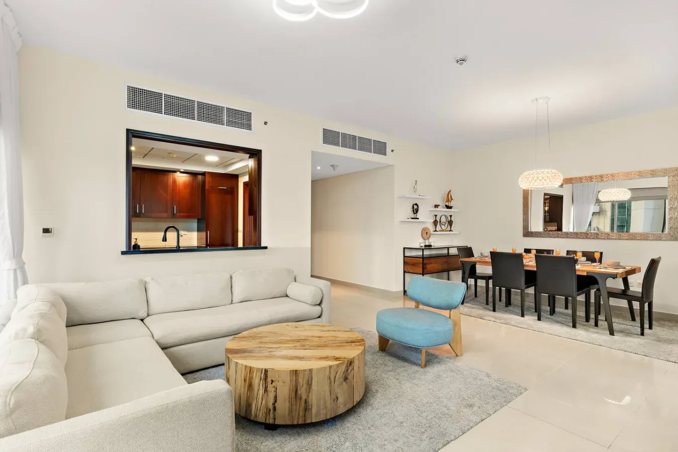A bright living and dining area with a sectional seating area and a dining table.