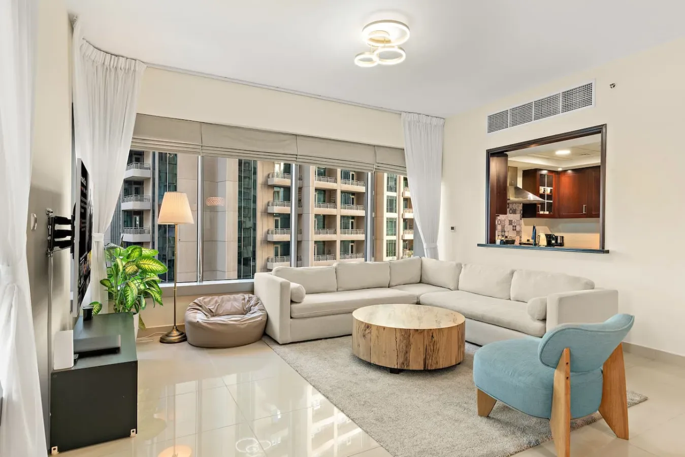A bright living room with a sectional seating area and large windows.