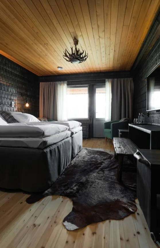 Dormitorio de un alojamiento de madera con dos camas individuales y una zona de estar.