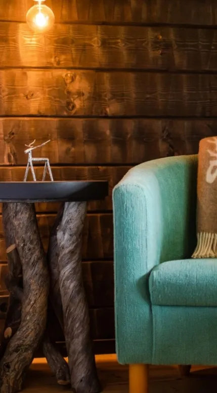 Bedroom with a rustic wooden nightstand and an armchair.