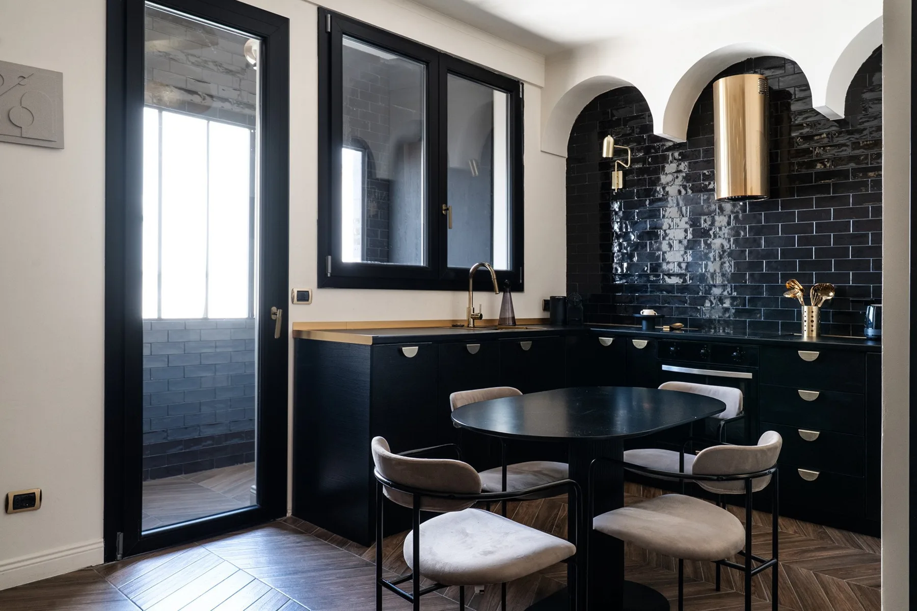 A modern kitchen and dining area with dark cabinets and a round table.