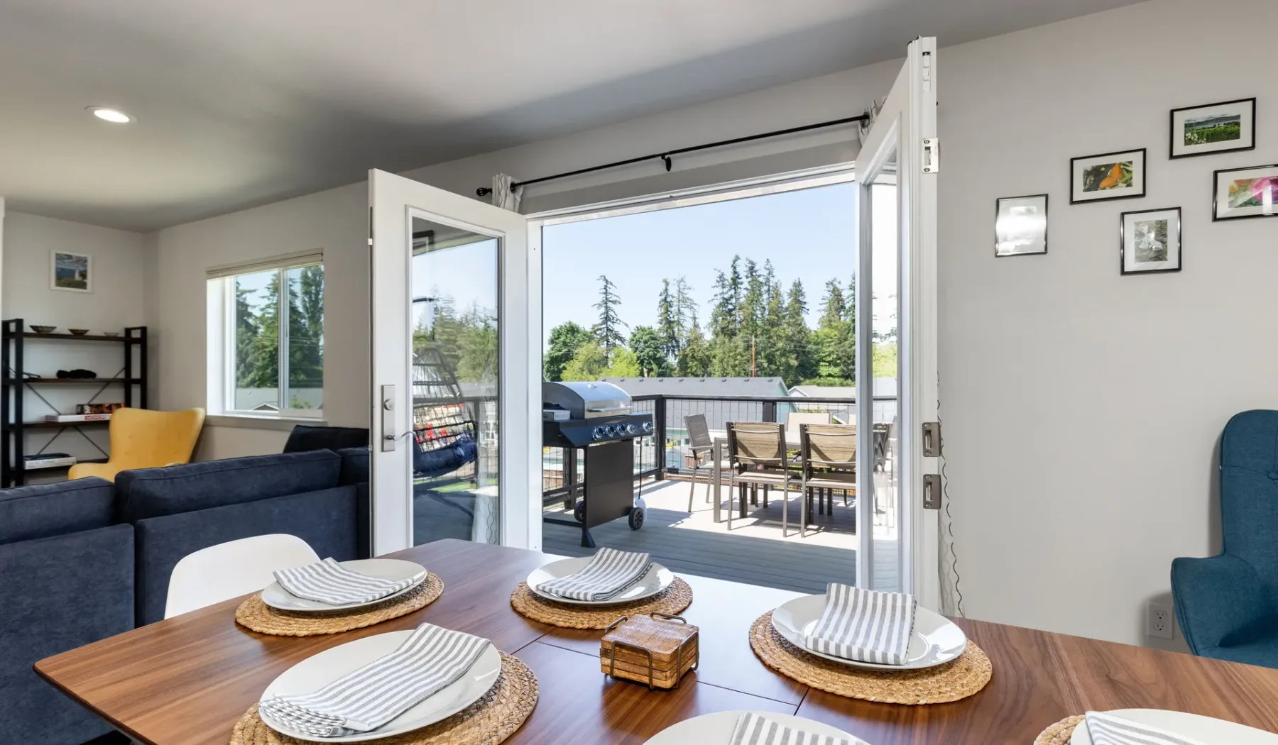 A living and dining area opens onto a patio with outdoor seating.