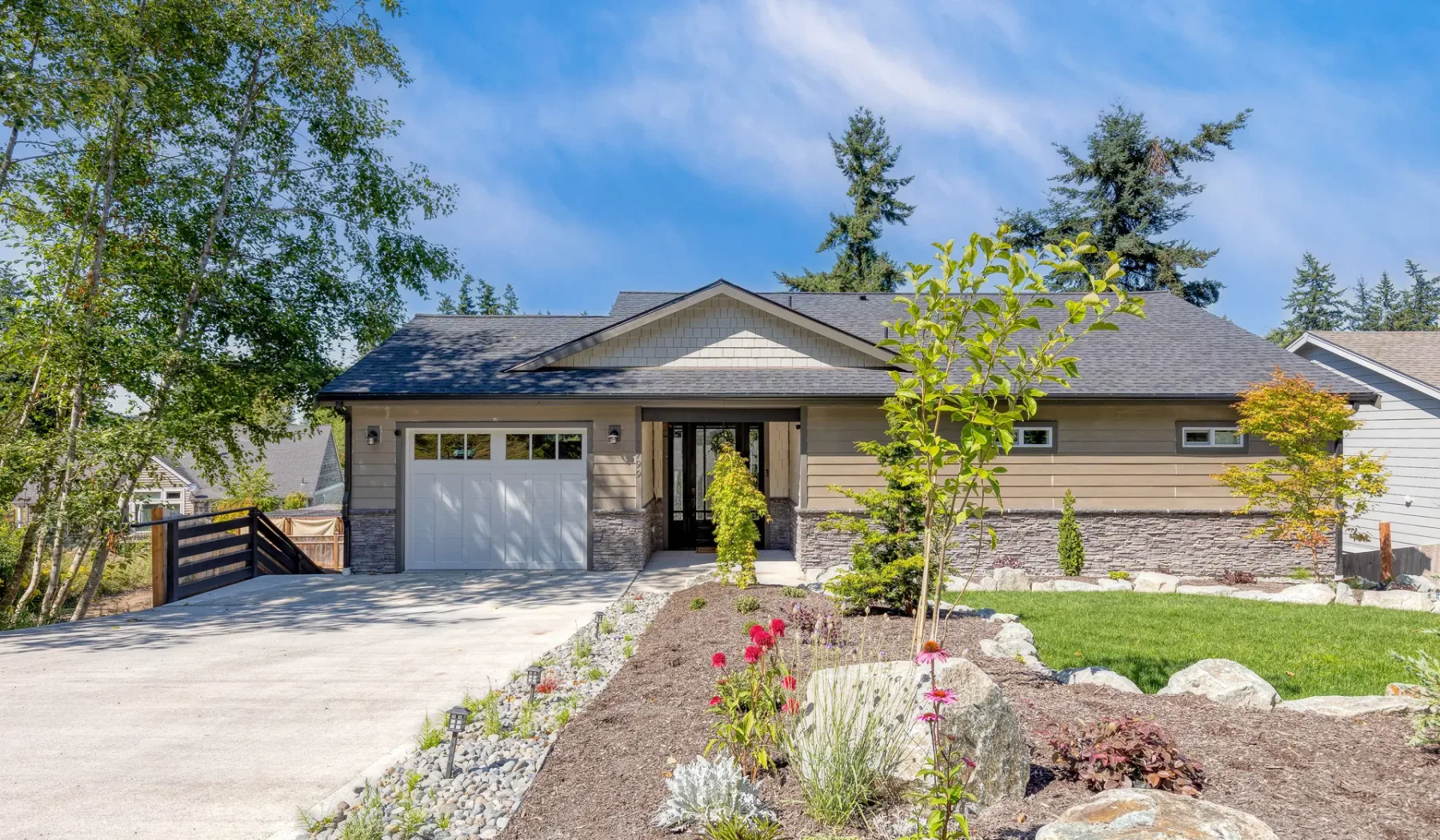 A single-story house with a garage, driveway, and landscaped front garden.