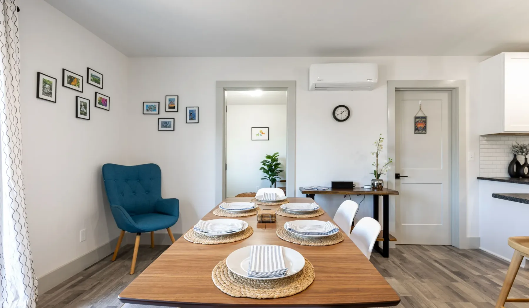 Comedor con una mesa de madera puesta y un sillón azul al lado.