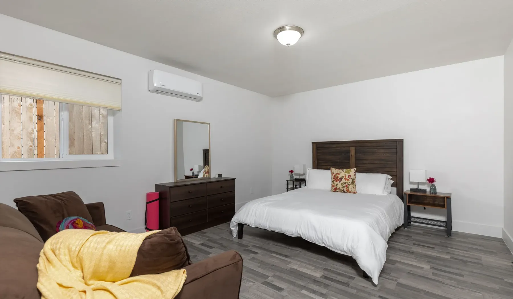 Un dormitorio con una cama, una cómoda y una zona de estar.