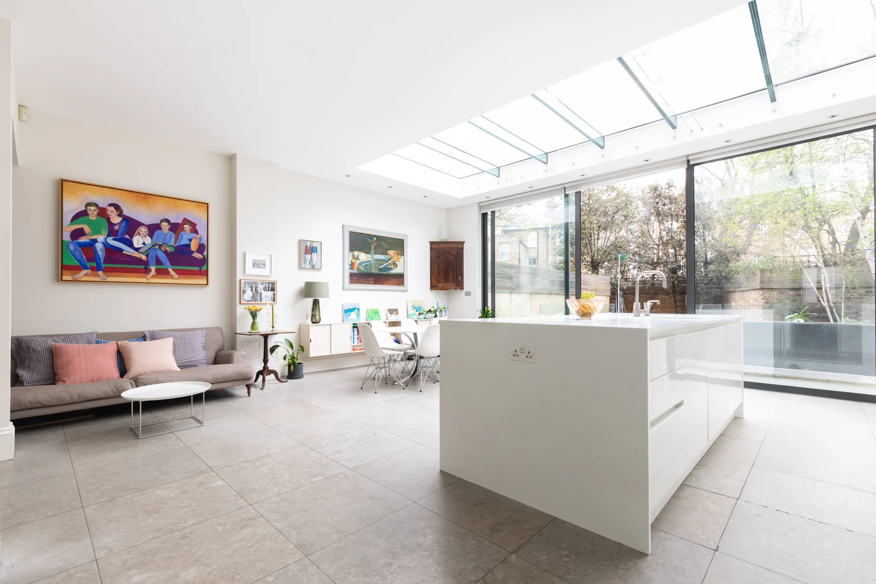 A bright open-plan living area and kitchen with large windows and a central island.
