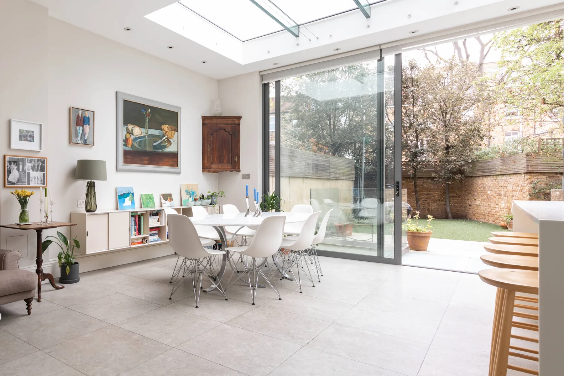 A bright dining area opens through glass doors onto a small garden patio.