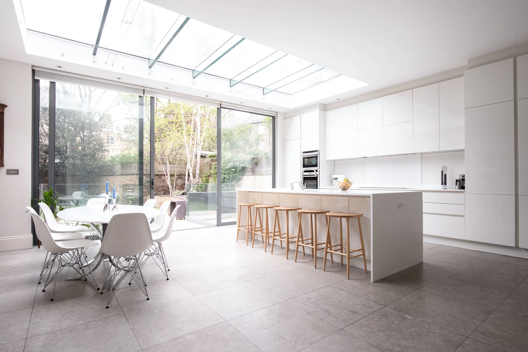 A bright modern kitchen and dining area with large windows and a central island.