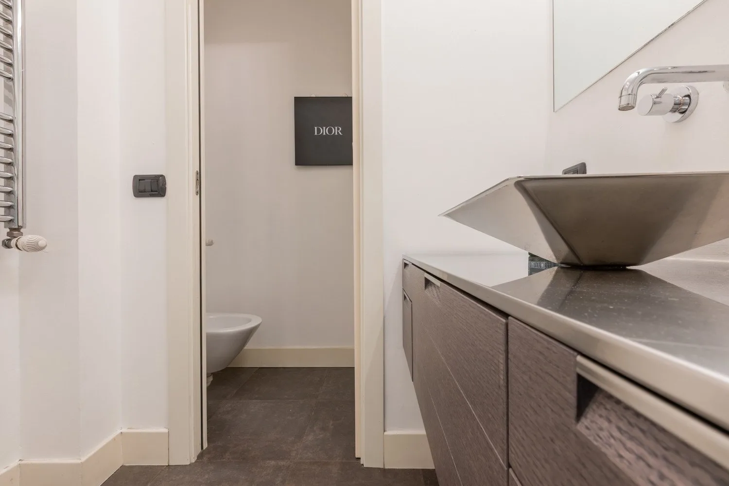 A bathroom vanity with a basin stands beside an open doorway.