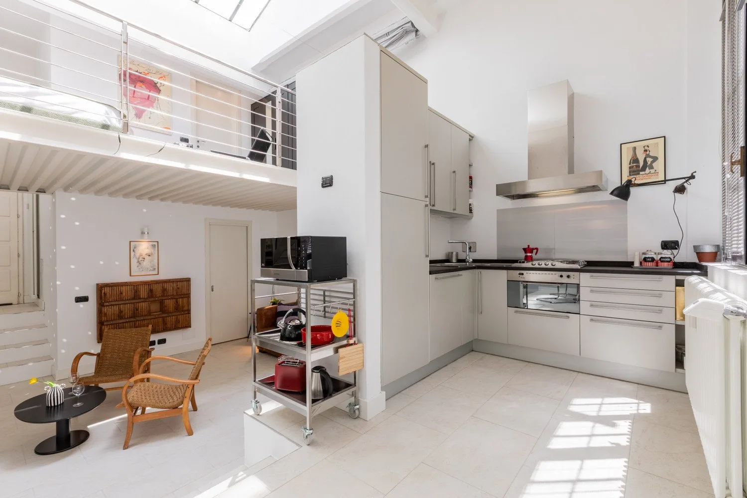 A bright open-plan kitchen and dining area with a loft above.