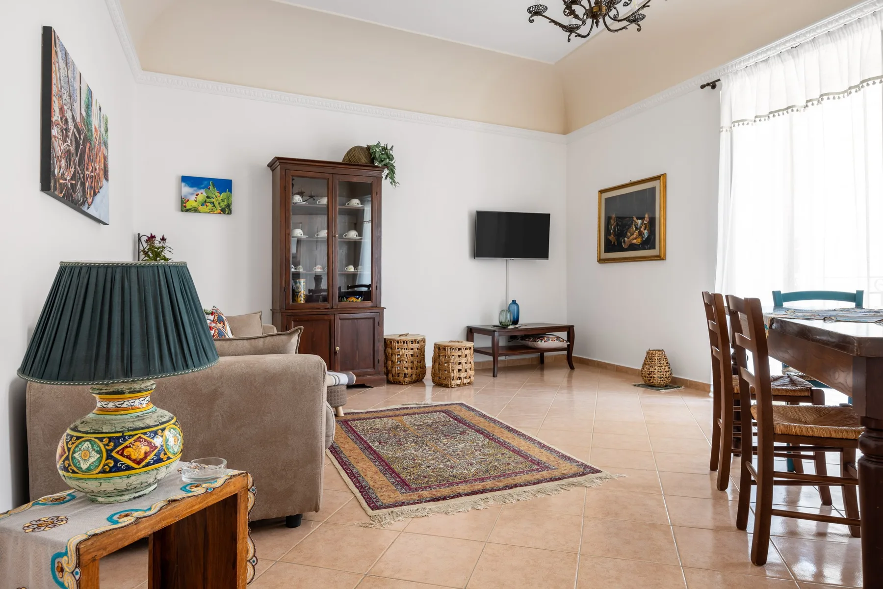 A living and dining room with seating, a television, and a dining table.