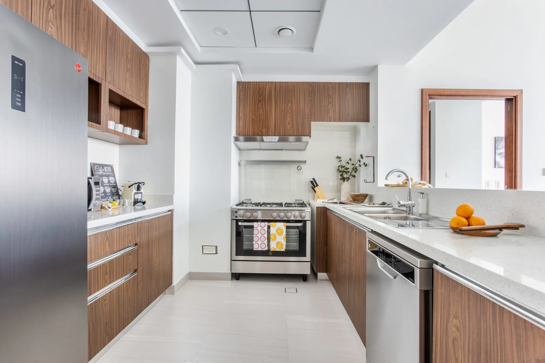 Una cocina moderna con gabinetes de madera, una estufa y una encimera larga.