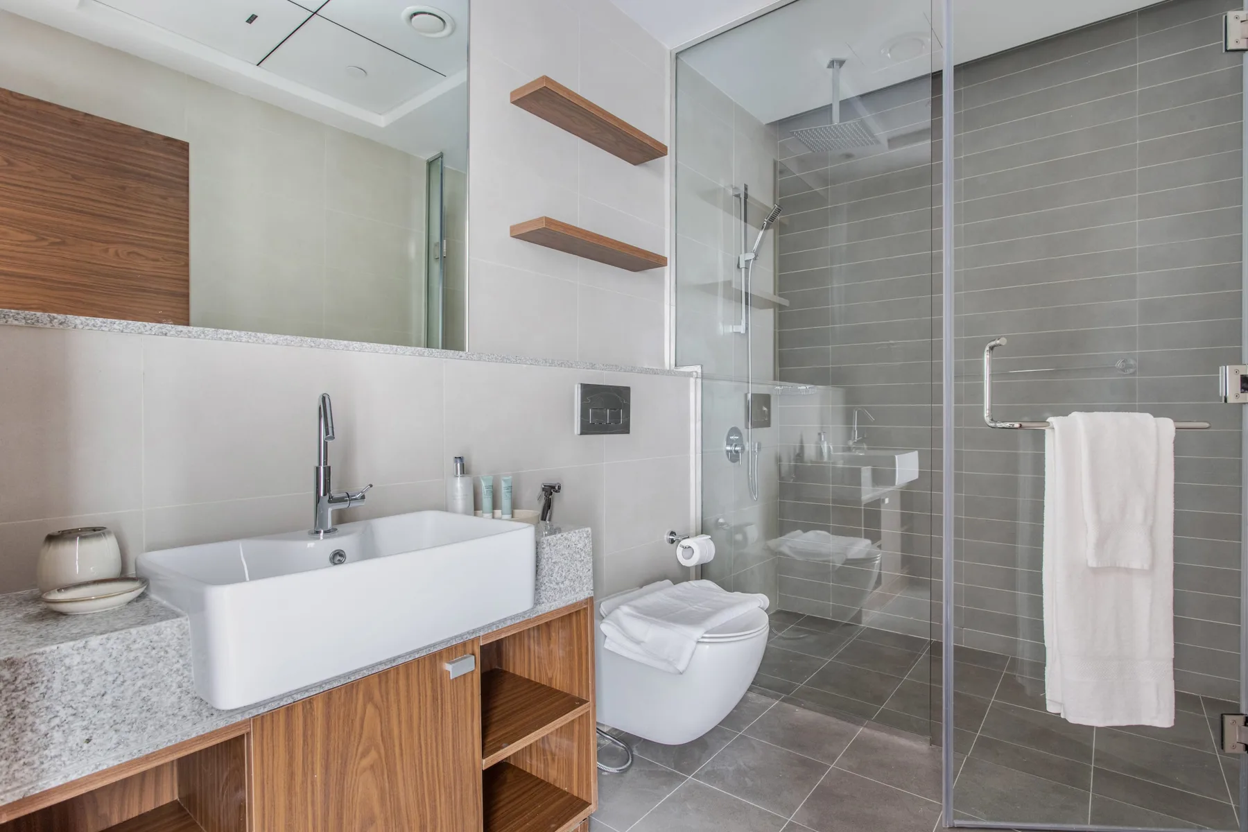 Un baño moderno con lavabo, inodoro y ducha de vidrio.