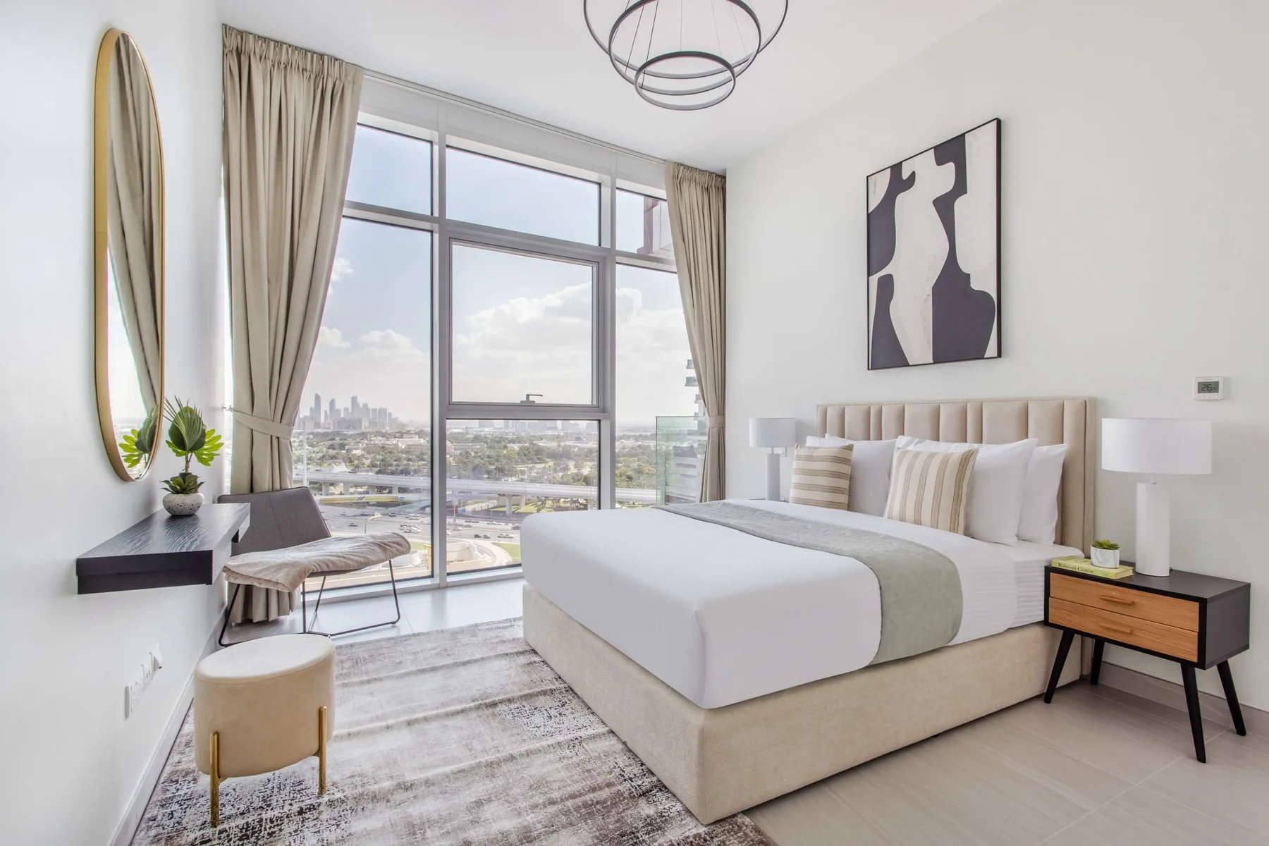 Un dormitorio luminoso con una ventana grande y una cama tendida.