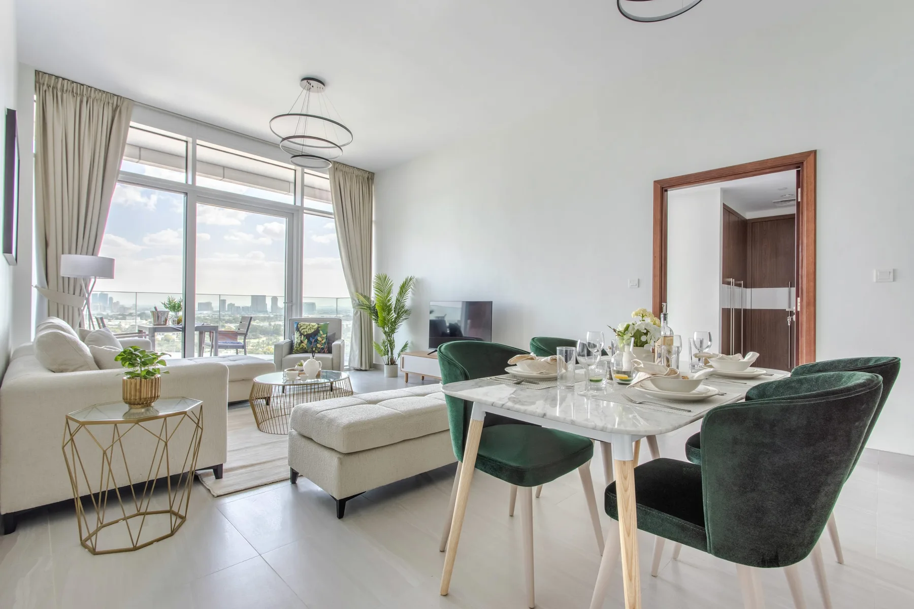 Una luminosa sala de estar y comedor con grandes ventanas, una mesa y asientos.