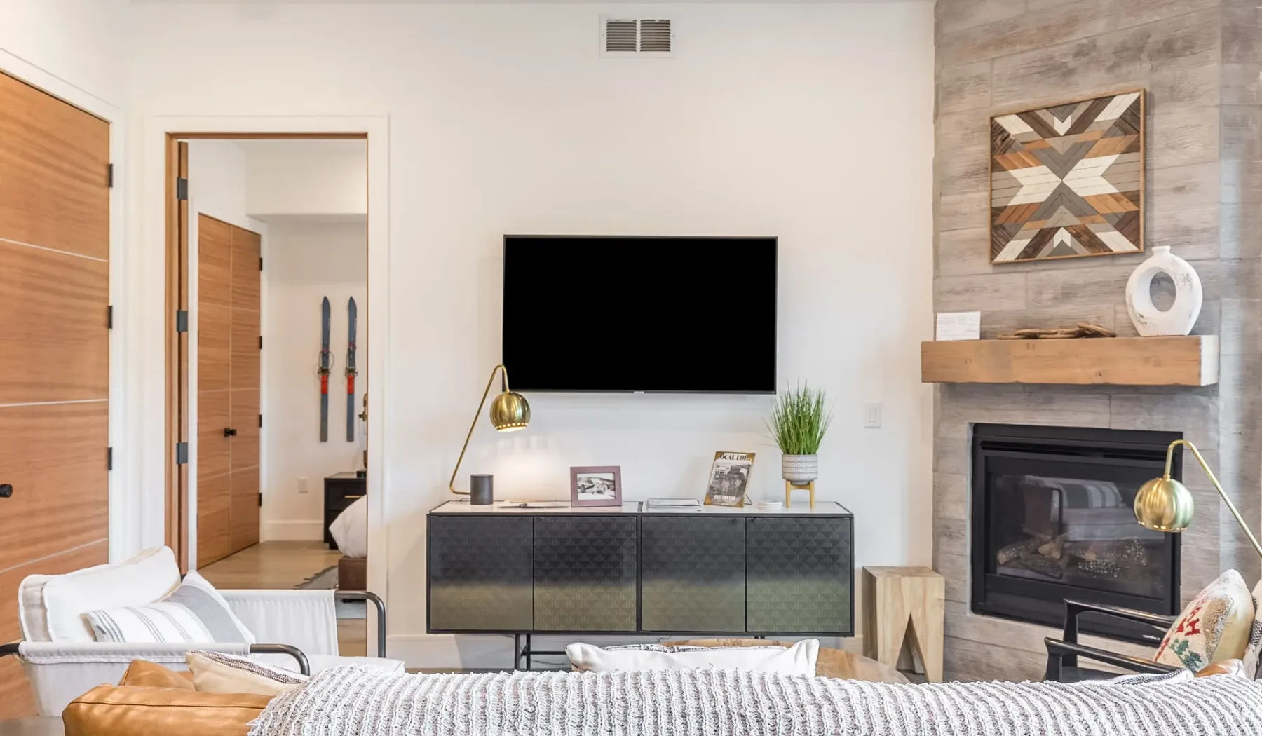 Una sala de estar con televisor, asientos y chimenea.