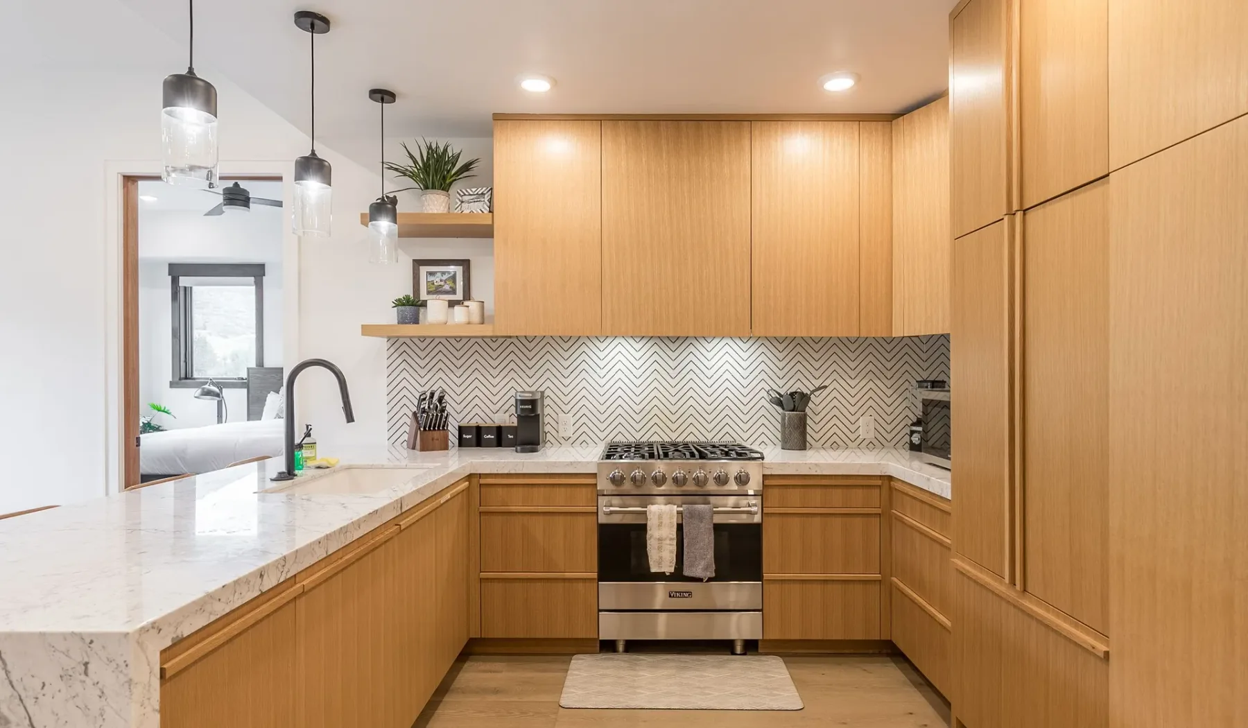 Una cocina moderna con gabinetes de madera, una encimera de piedra y un salpicadero estampado.