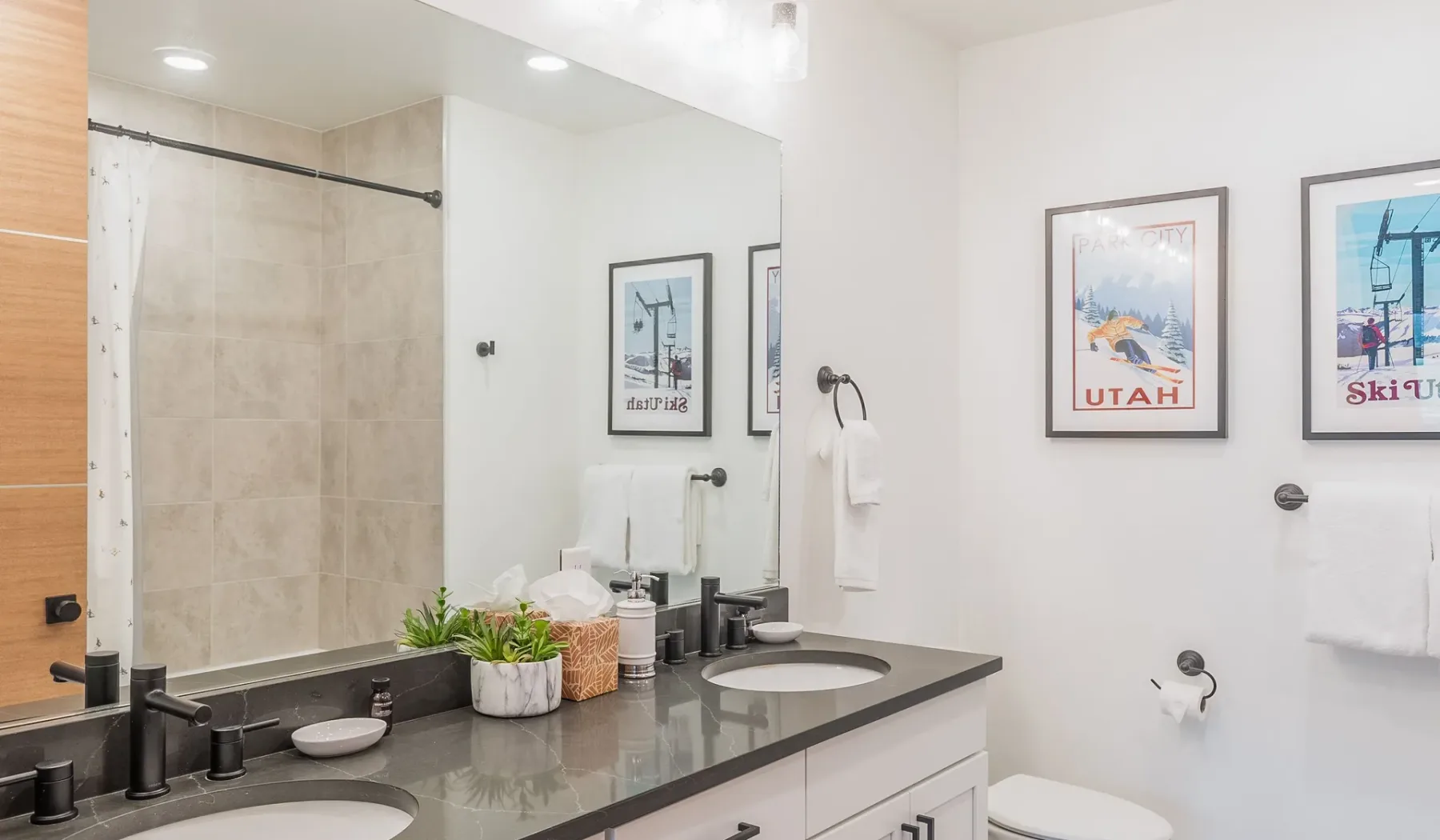 Un baño luminoso con un amplio tocador, lavabo y ducha.