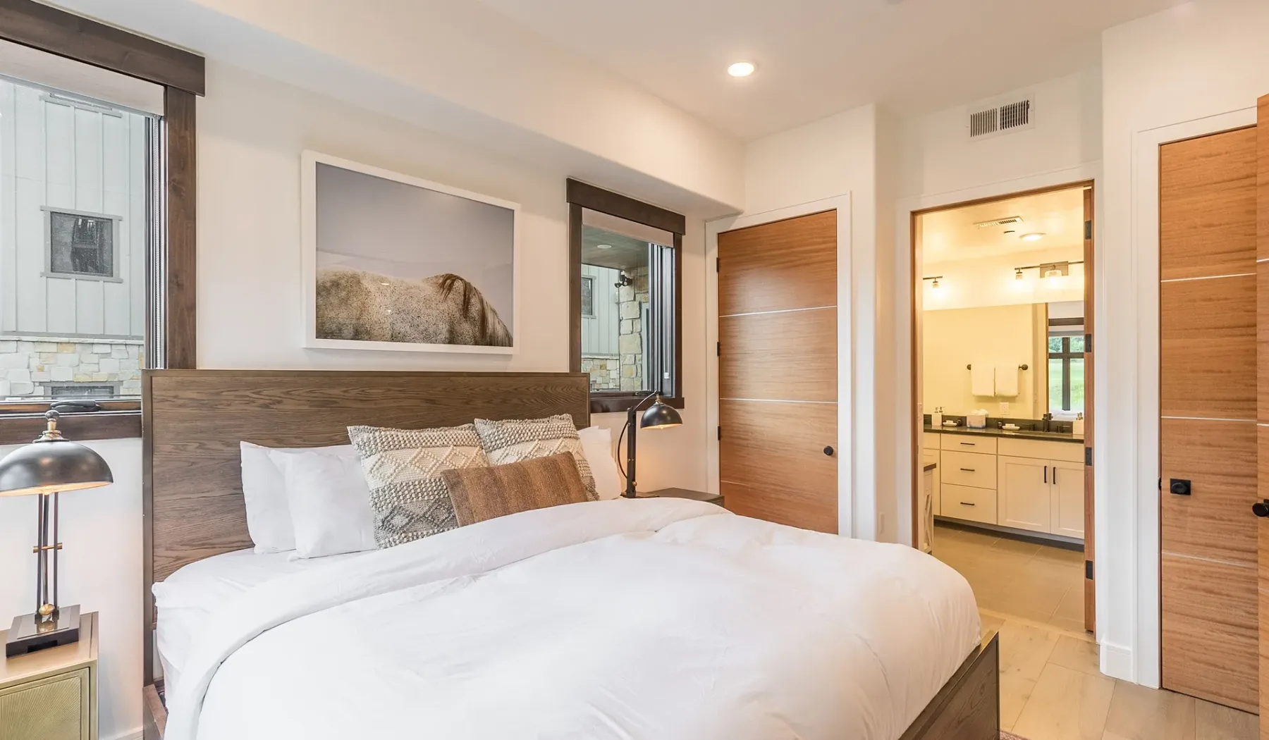 Un dormitorio con una cama, un cabecero de madera y una obra enmarcada.