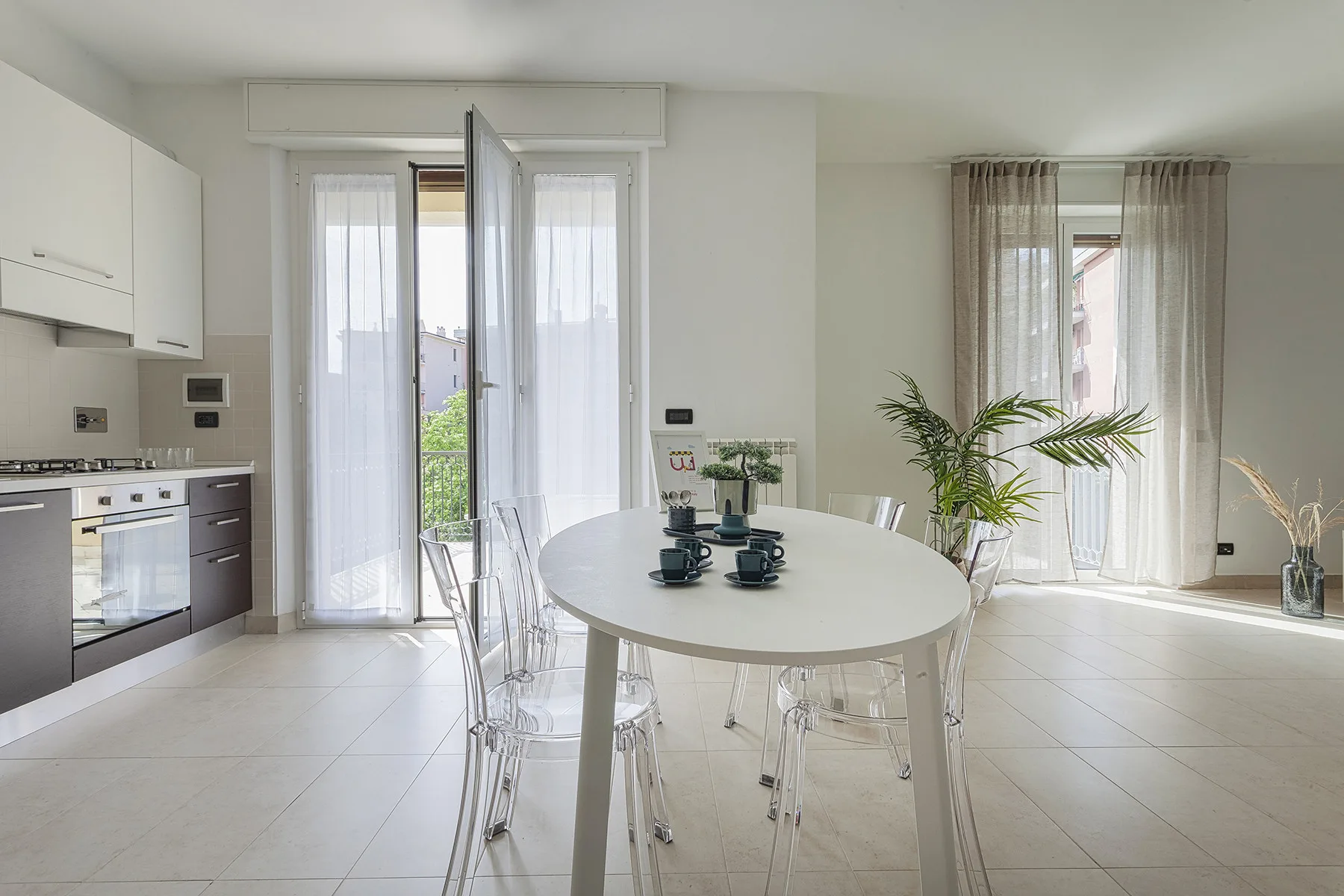 Una cocina y comedor luminosos con una mesa redonda y grandes ventanas.