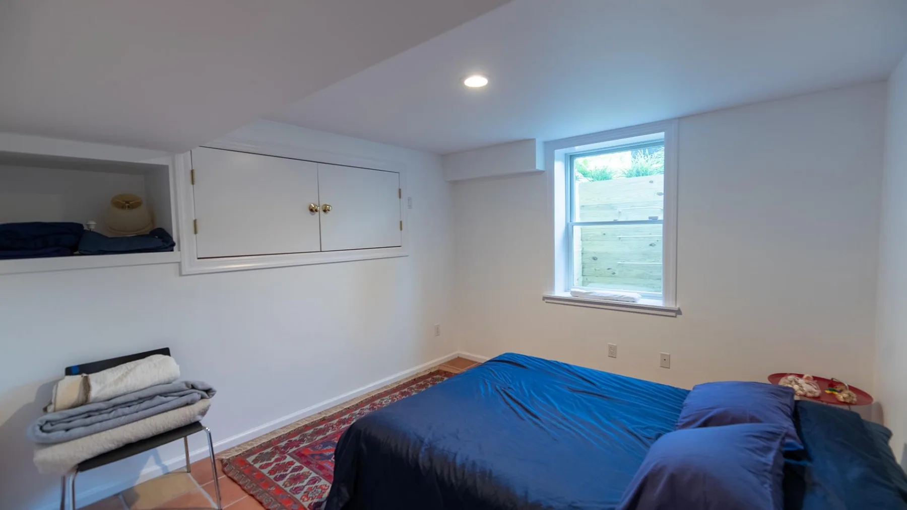 Un dormitorio con una cama y una ventana pequeña.
