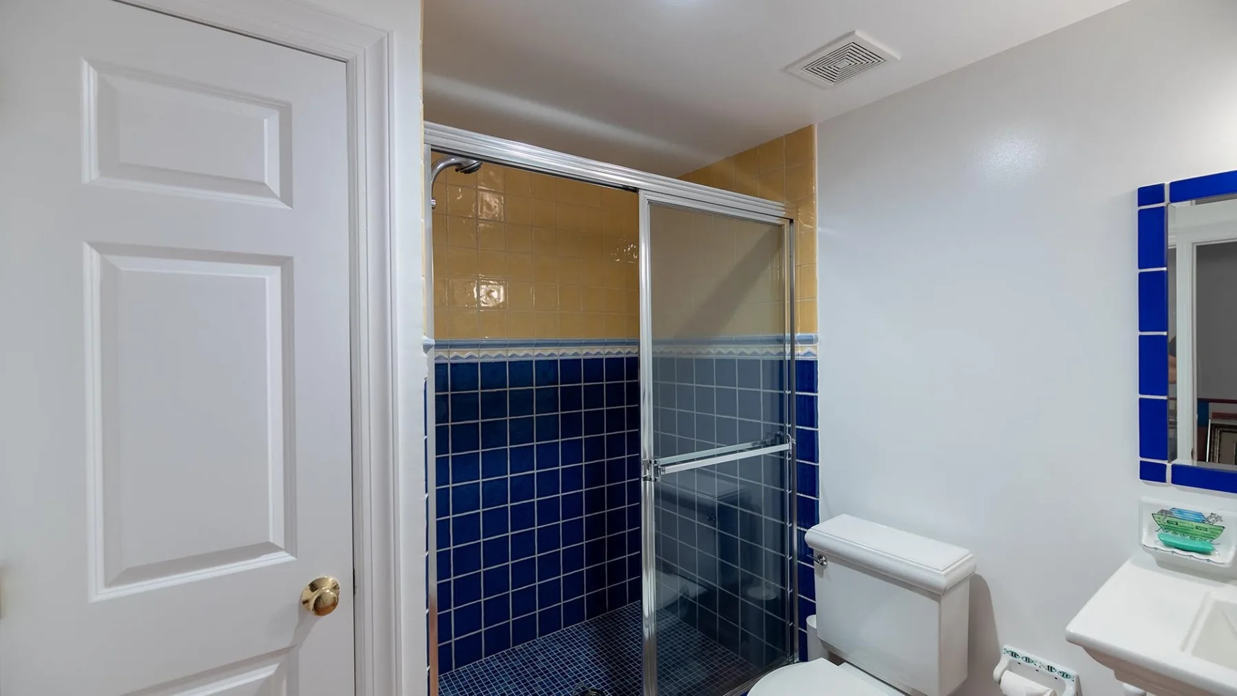 Un baño con ducha alicatada, inodoro y lavabo.