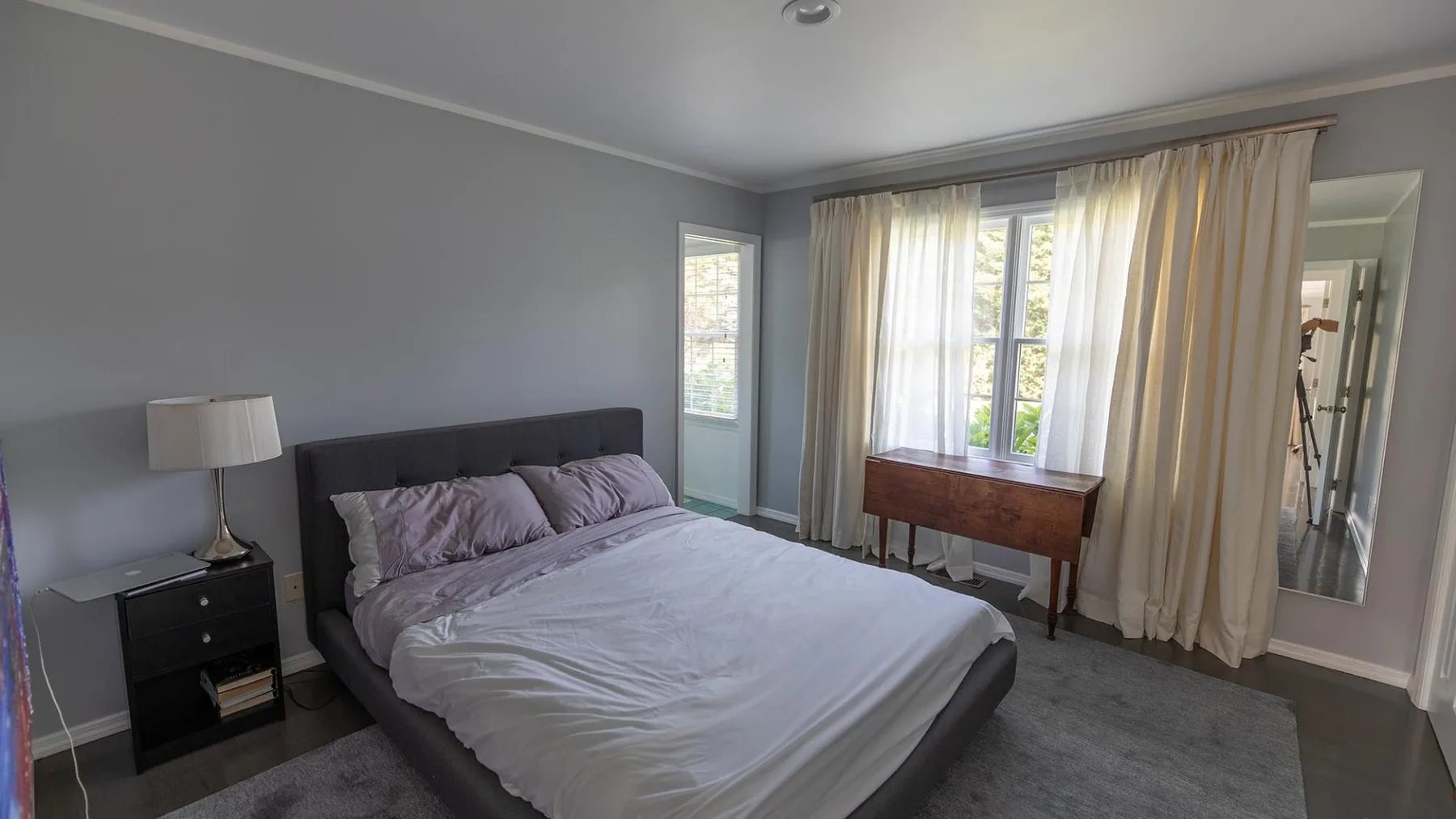 Un dormitorio con una cama y ventanas con cortinas.