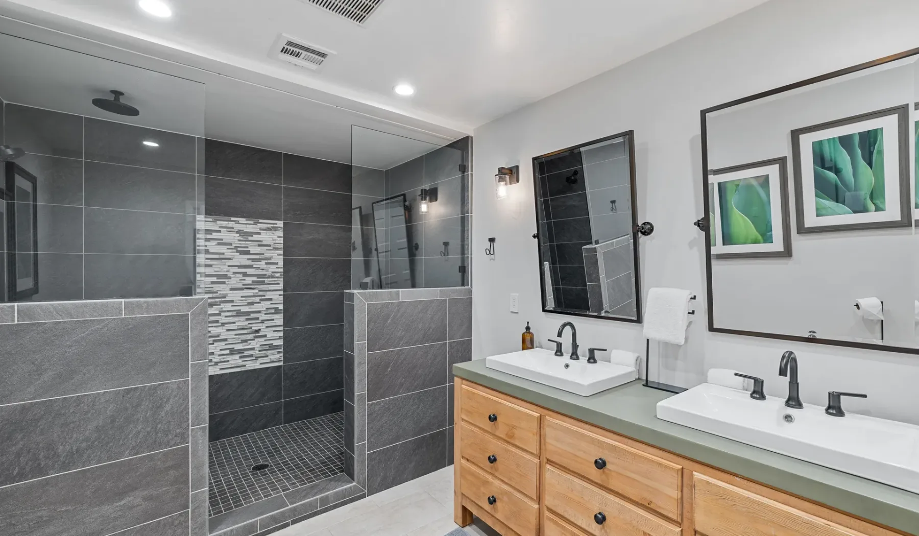 Un baño moderno con lavabo doble y ducha de cristal.