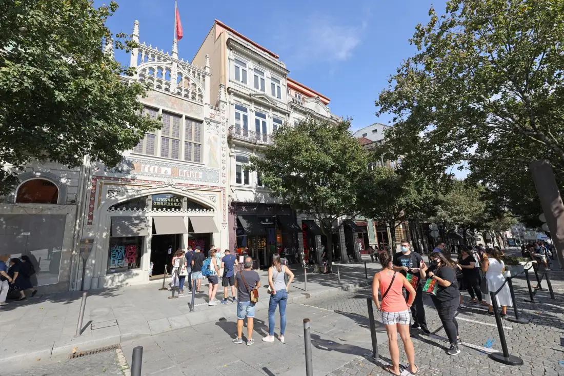 A tree-lined city street with ornate buildings and pedestrians.