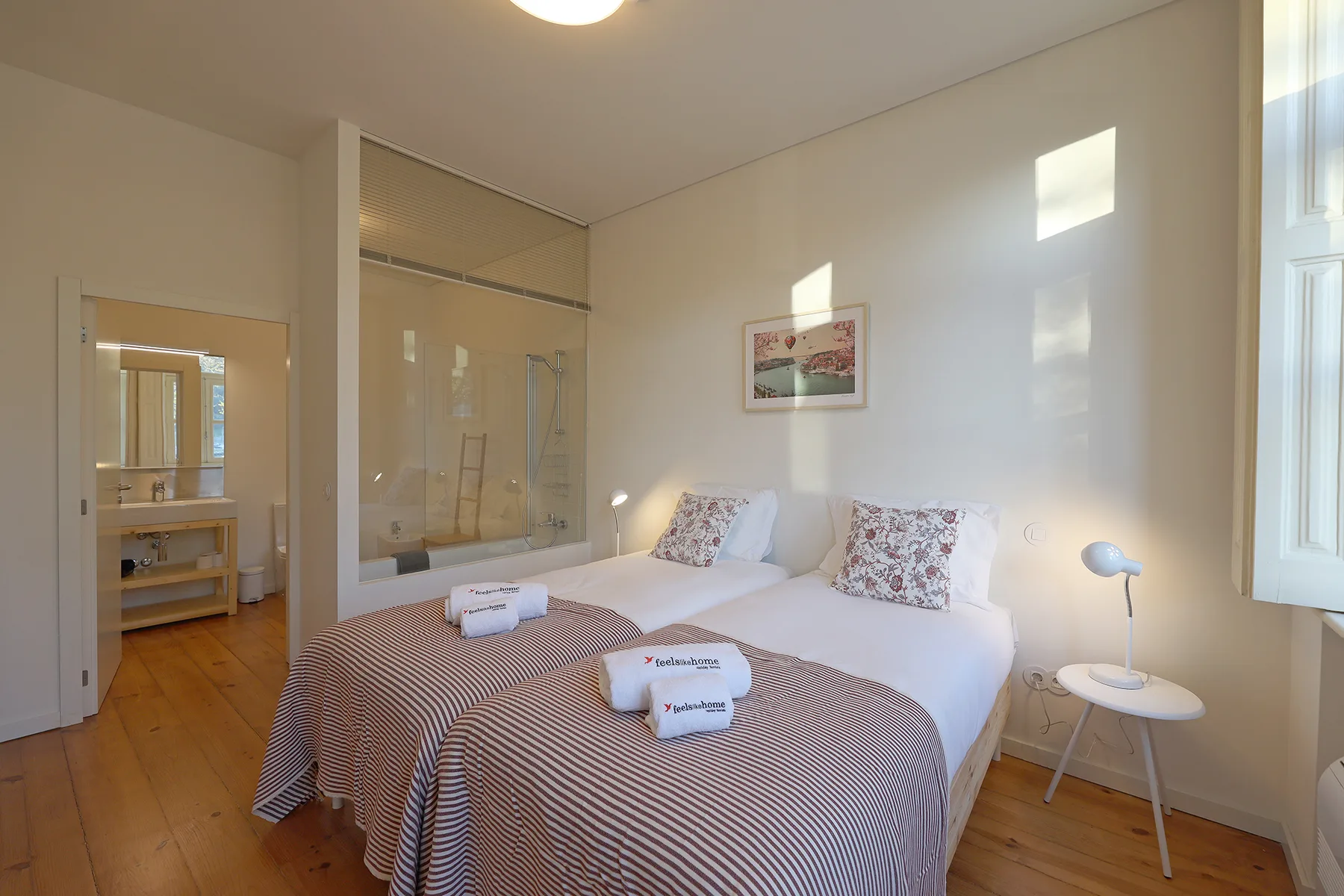 A bedroom with a bed, bedside table, and glass shower enclosure.