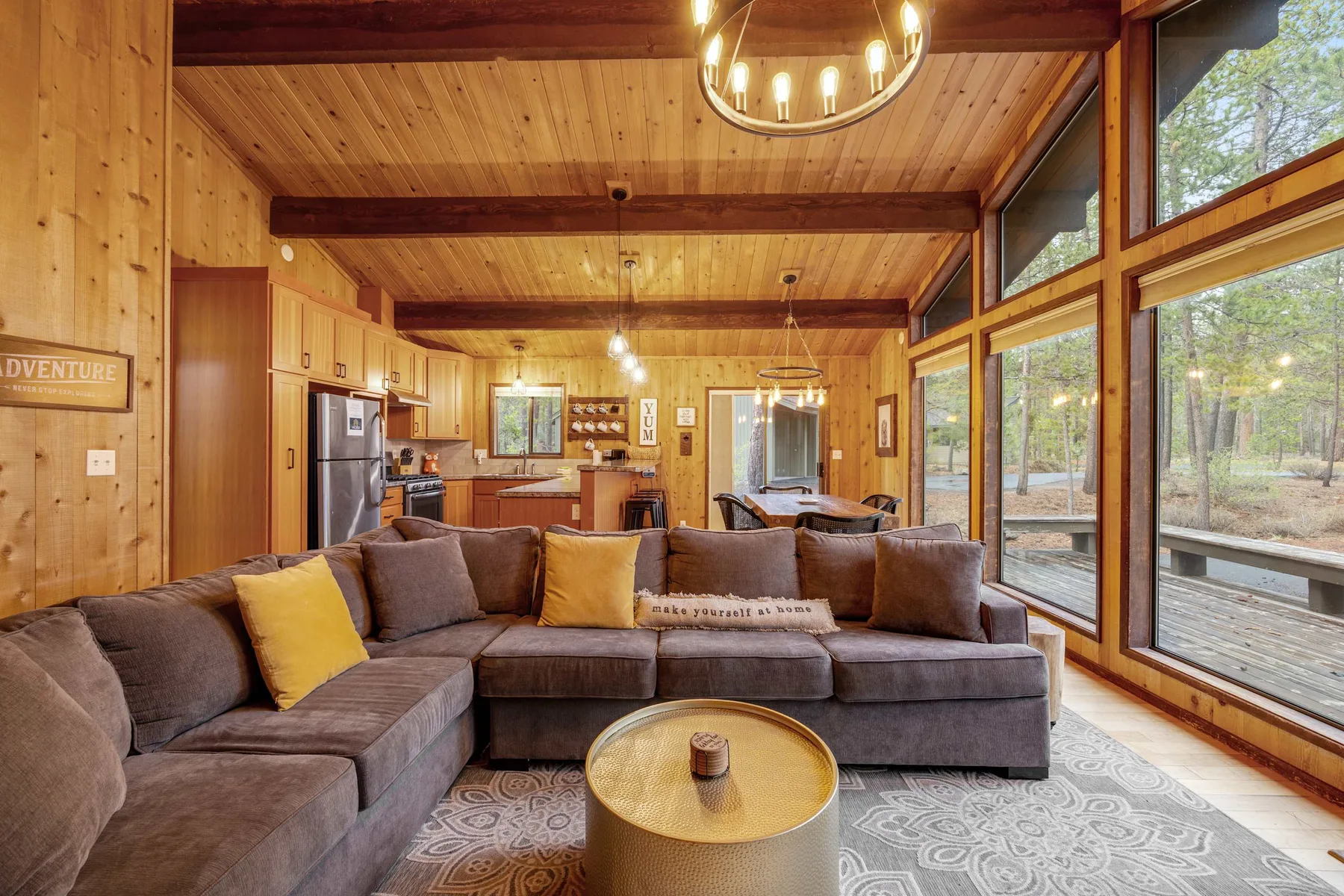 Una sala con paredes de madera, asientos seccionales y grandes ventanas.