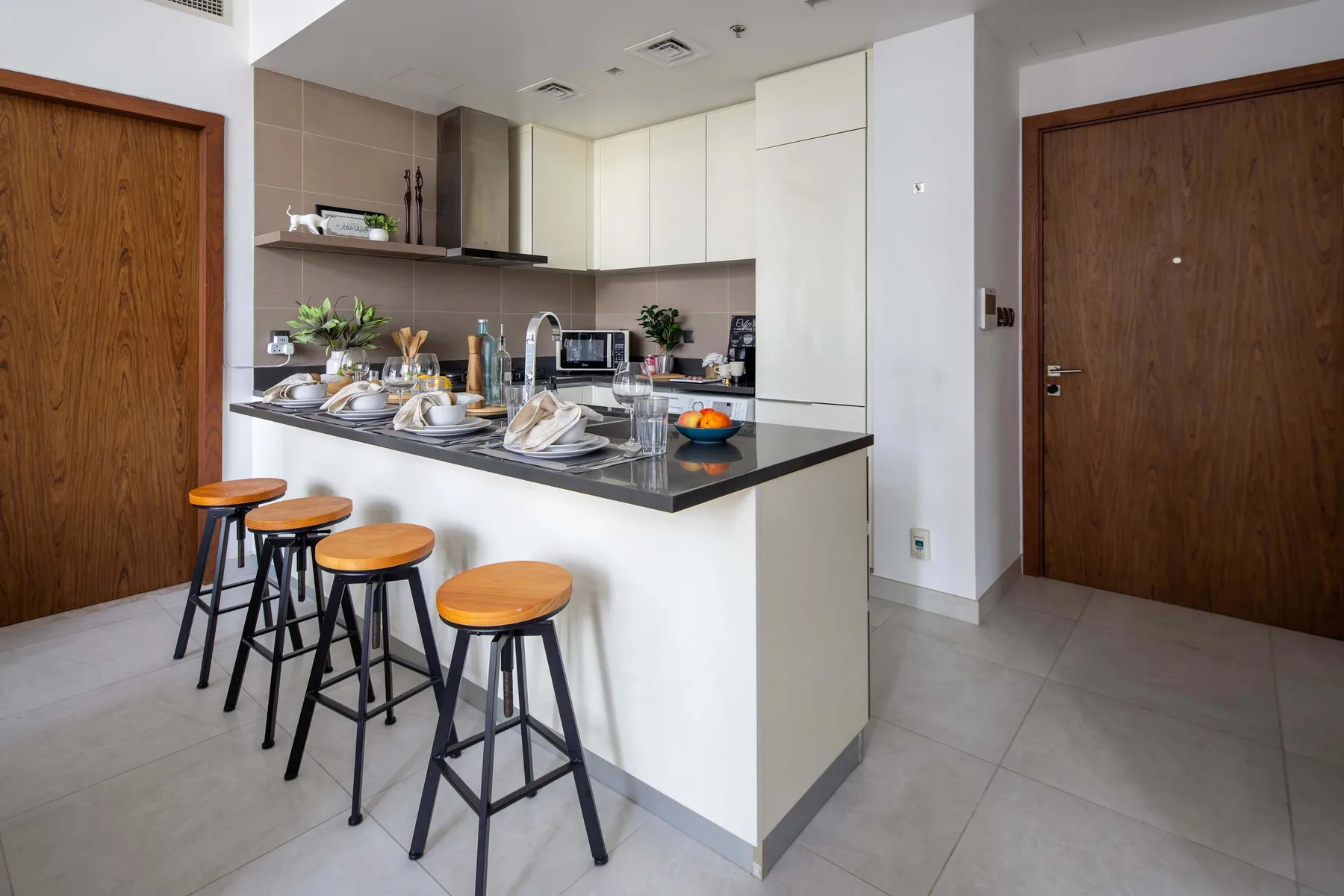 Una cocina moderna con una barra, taburetes y gabinetes.