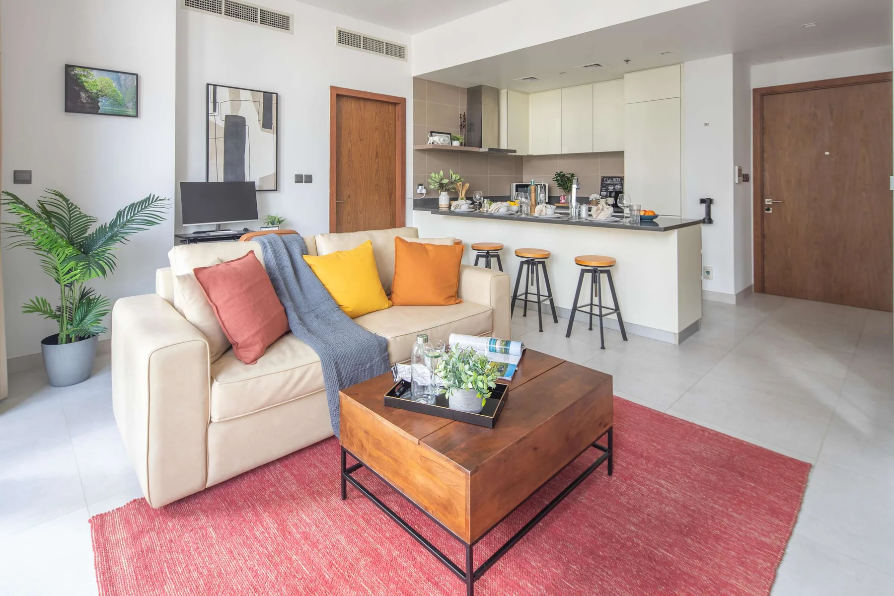 Sala de estar y cocina de concepto abierto con sofá, mesa de centro y barra de desayuno.