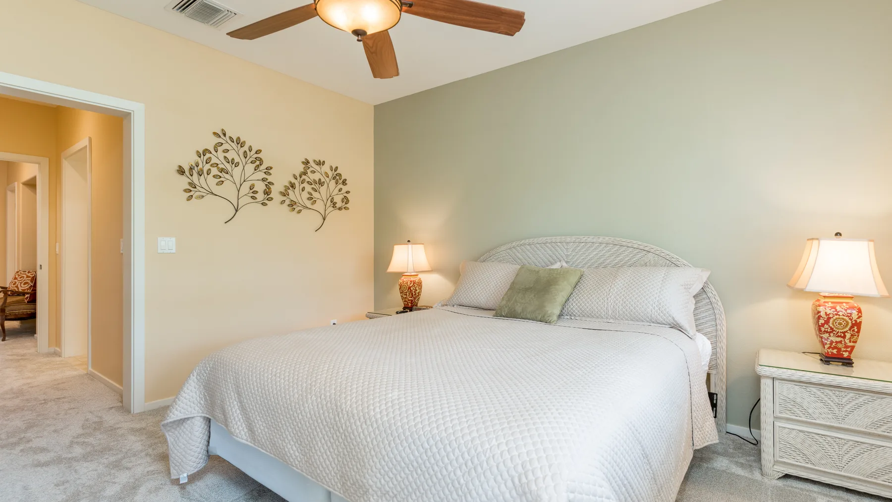 Un dormitorio con una cama bien hecha y lámparas de noche.